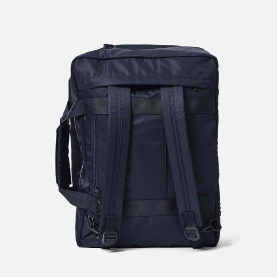 AY Studios Weekend Bag Navy Blue reistas, rechtop, met de rugzakriemen zichtbaar