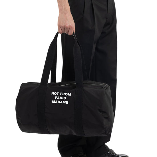 Drôle de Monsieur Nylon Slogan Gym Bag Black gedragen op model bij Checkpoint Mol
