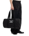 Drôle de Monsieur Nylon Slogan Gym Bag Black gedragen op model bij Checkpoint Mol