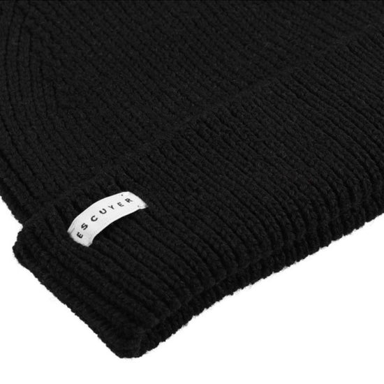 Escuyer Ribbed Merino Beanie muts in zwart – detail van ribbreisel en merklabel