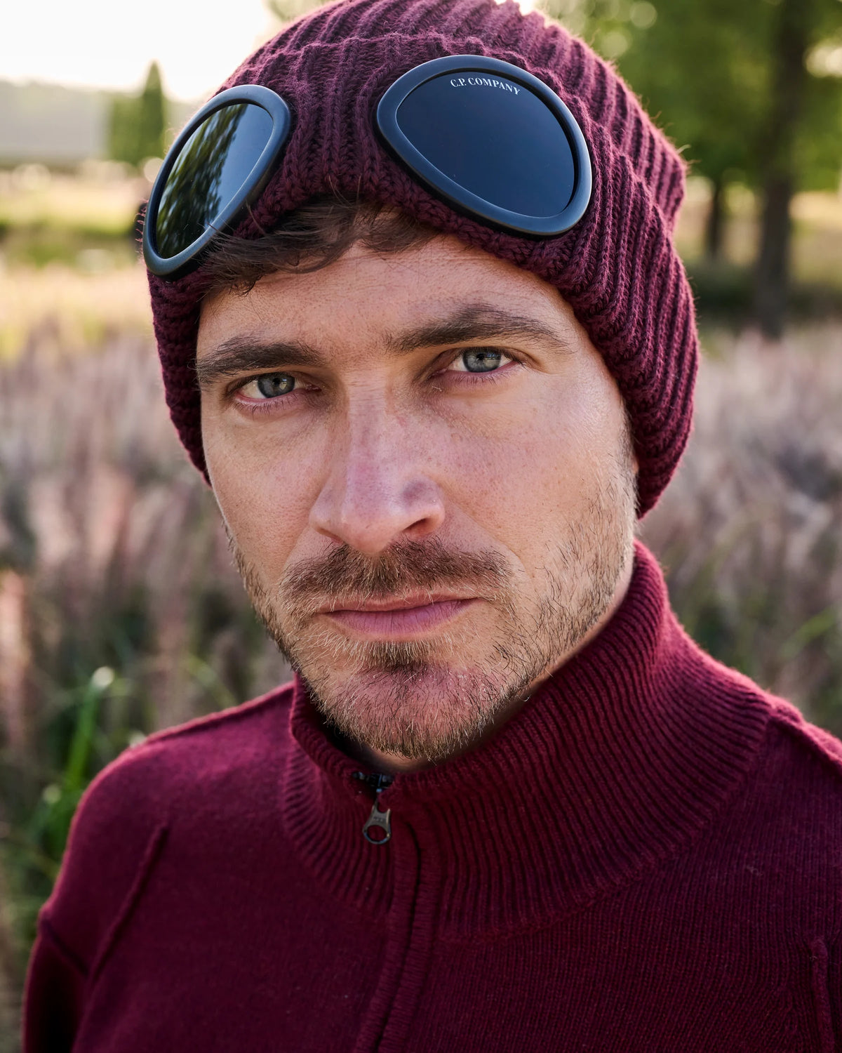 Bordeaux C.P. Company halfzip en goggle beanie in close-up op Begijnhoeve in Mol-Postel.