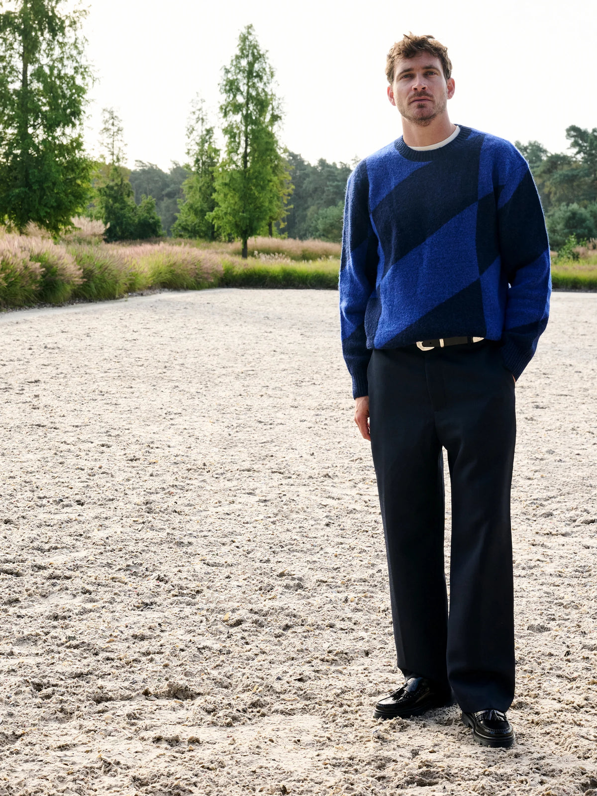 Blauwe Castart trui met zwarte broek en loafers op Begijnhoeve in Mol-Postel.