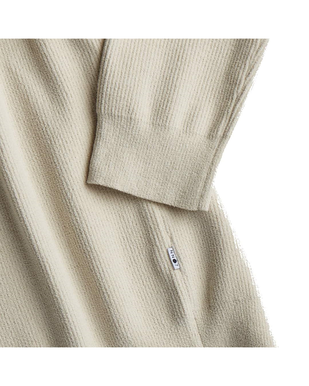 NN.07 Danny ecru ribgebreide trui, detail mouwboord en zijlabel
