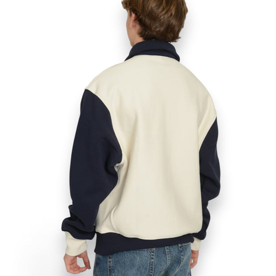 PAL Sporting Goods Pre Game Half Zip in Marshmallow, gedragen achteraanzicht met donkerblauwe mouwen en boord.