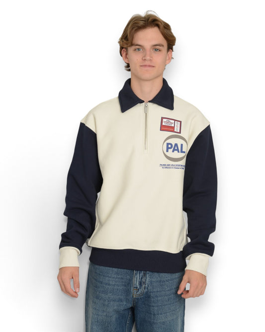 PAL Sporting Goods Pre Game Half Zip in Marshmallow, gedragen vooraanzicht met donkerblauwe mouwen, kraag en PAL-borstlogo.