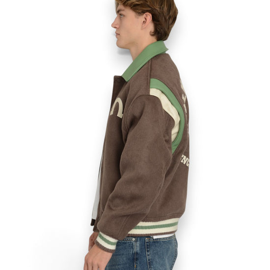 PAL Sporting Goods Ranch Varsity Jacket in Deep Mahogany, gedragen zijaanzicht met groene kraag en schouderpanelen.