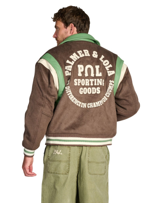 PAL Sporting Goods Ranch Varsity Jacket in Deep Mahogany, gedragen achteraanzicht met rugborduring en groene Gallop Barrel Leg broek.