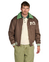 PAL Sporting Goods Ranch Varsity Jacket in Deep Mahogany, gedragen vooraanzicht met groene kraag en Gallop Barrel Leg broek.