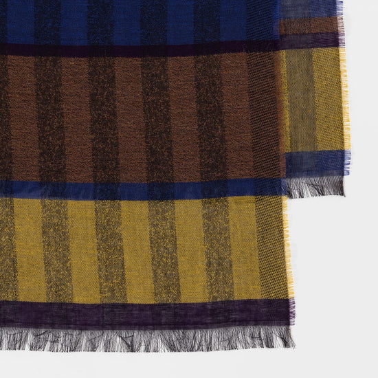 Detail van Paul Smith sjaal met blauwe, bruine en gele vakken en fijne franjes