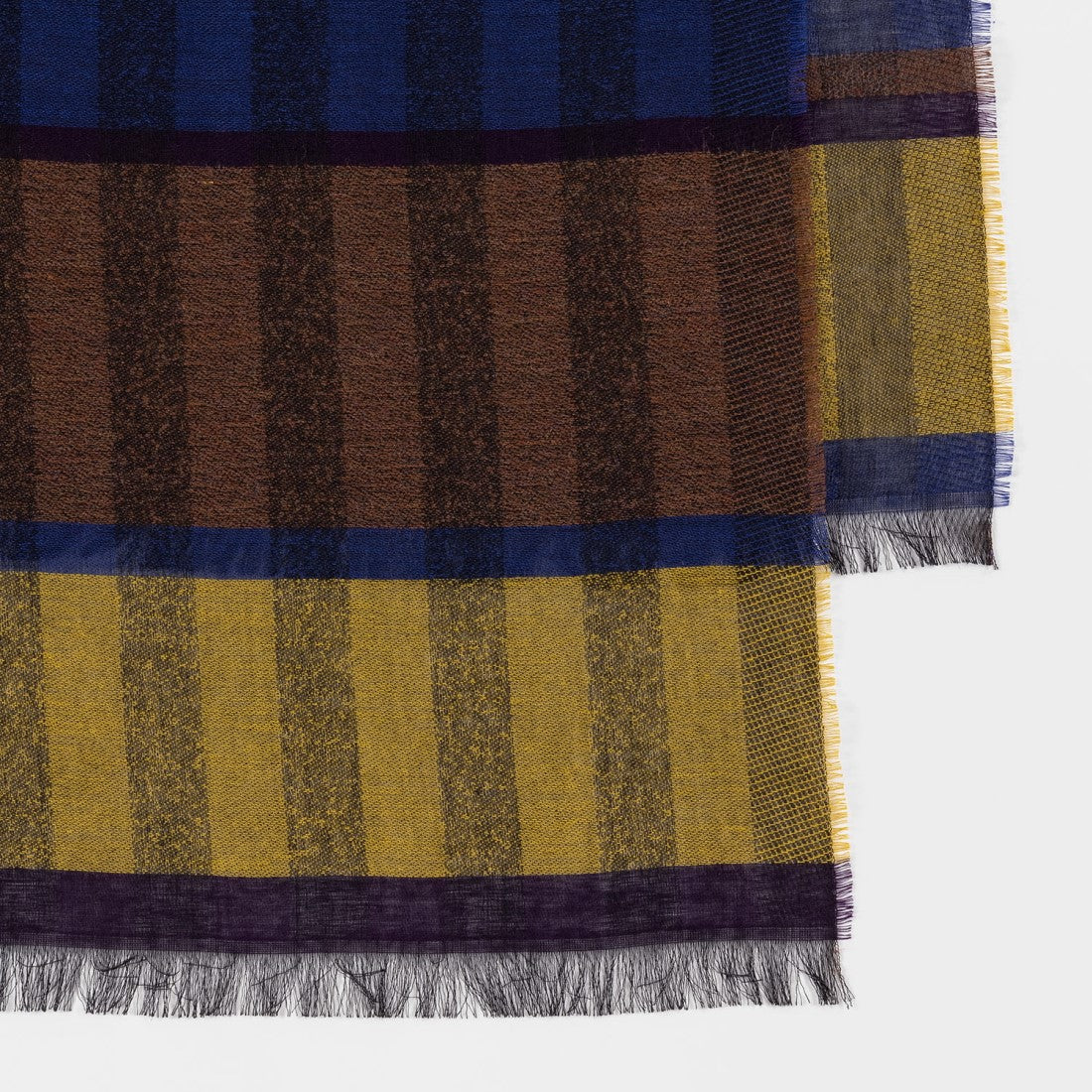 Detail van Paul Smith sjaal met blauwe, bruine en gele vakken en fijne franjes