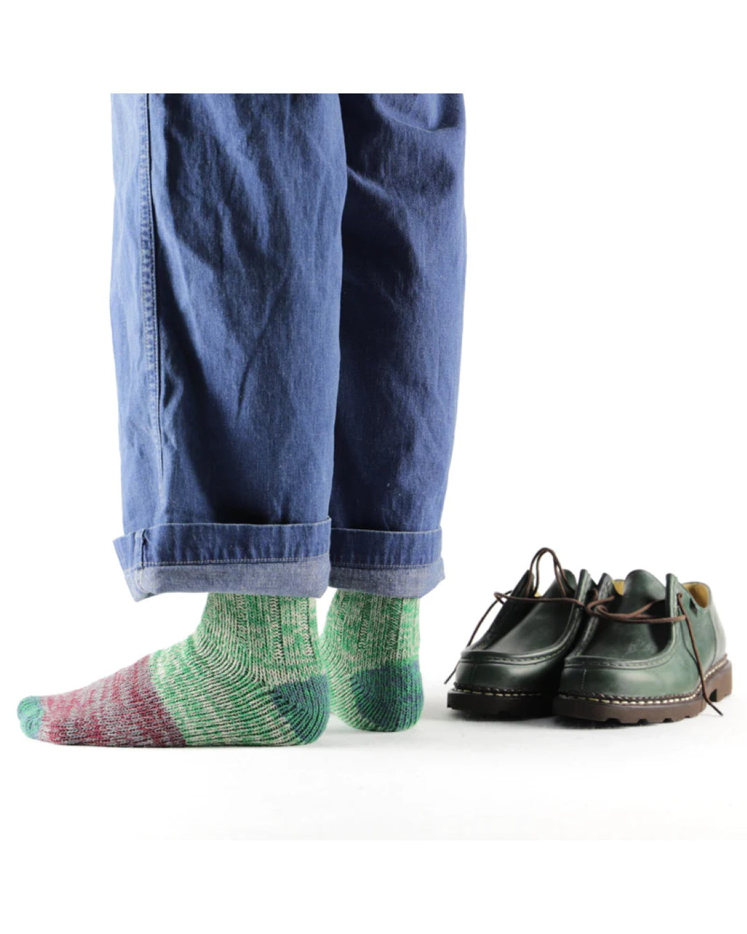 Thunders Love Charlie Green sokken gedragen onder een blauwe broek, naast groene schoenen