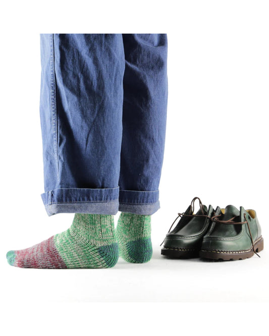 Thunders Love Charlie Green sokken gedragen onder een blauwe broek, naast groene schoenen