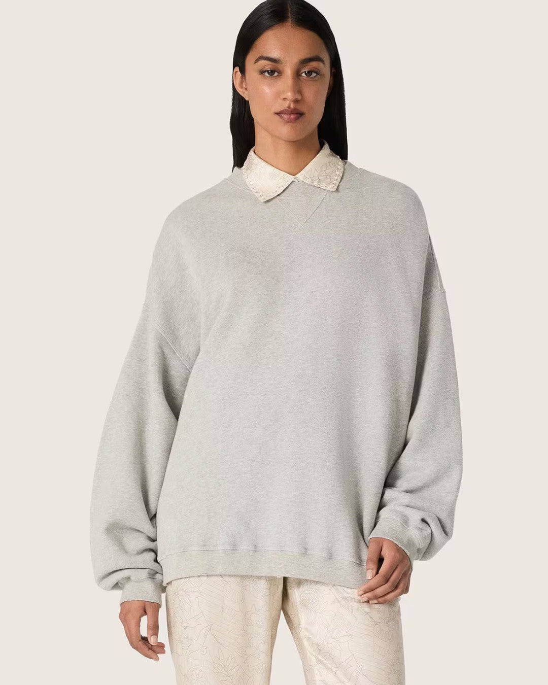 Vrouwelijk model met Golden Goose unisex sweatshirt in grijs melange en geborduurd Golden logo op de rug