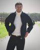 Donker indigo overshirt en jeans met lichte knitwear op het pad langs de paddock op Begijnhoeve in Mol-Postel.