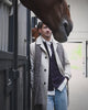 Lichte overjas met donkere cardigan, sjaal en lichtblauwe jeans naast een paard op Begijnhoeve in Mol-Postel.