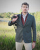Blauwgroene blazer met bordeaux tussenlaag, lichtblauw hemd en beige broek tussen het groen op Begijnhoeve in Mol-Postel.