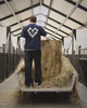 Donker T-shirt met bloemenprint over een witte longsleeve op een hooikar in de paardenstal op Begijnhoeve in Mol-Postel.