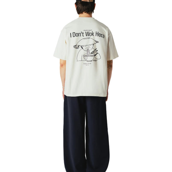 Achterkant van de Woodbird WBBaine Wok Tee Off White met grote “I don’t wok here” rugprint